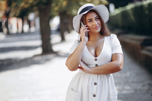 Giovane donna con cappello parlando al telefono