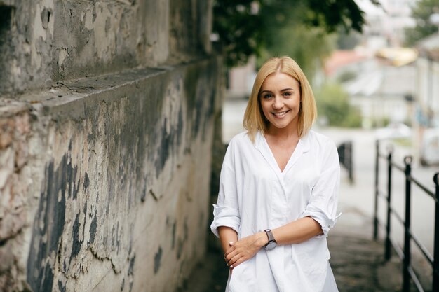 Giovane donna con computer portatile e smart phone. Bella ragazza studente che lavora al computer portatile all&#39;aperto