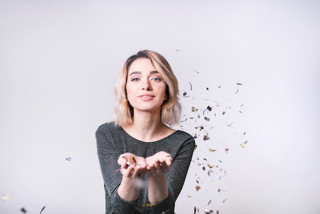 Giovane donna con coriandoli di volo