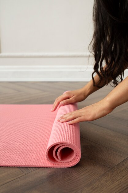 Giovane donna con elementi essenziali per lo yoga