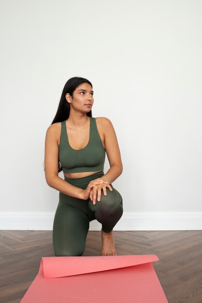Giovane donna con elementi essenziali per lo yoga