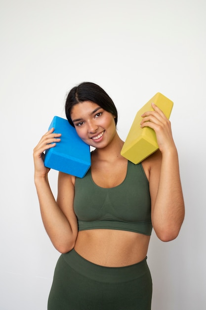 Giovane donna con elementi essenziali per lo yoga