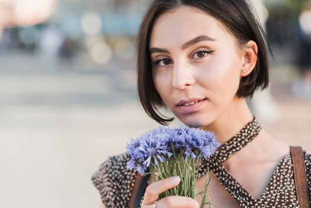 Giovane donna con fiori all&#39;esterno