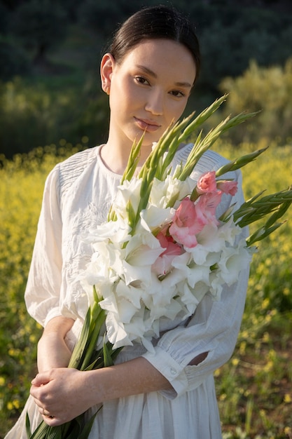 Giovane donna con gladiolo in natura