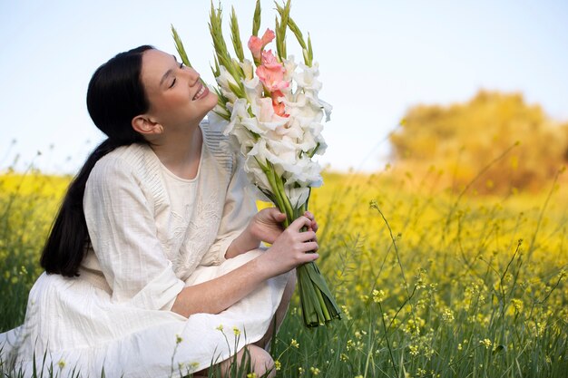 Giovane donna con gladiolo in natura