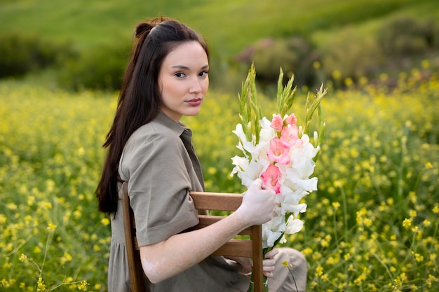Giovane donna con gladiolo in natura