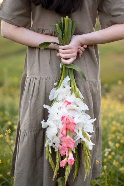 Giovane donna con gladiolo in natura