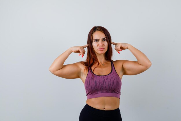 Giovane donna con i capelli lunghi che indossa abbigliamento sportivo