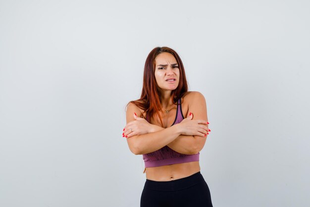 Giovane donna con i capelli lunghi che indossa abbigliamento sportivo