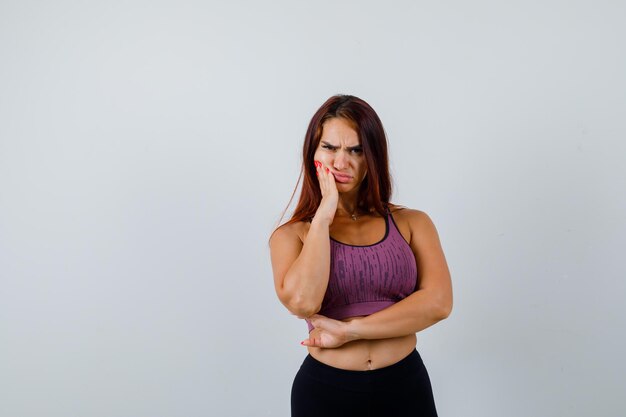 Giovane donna con i capelli lunghi che indossa abbigliamento sportivo