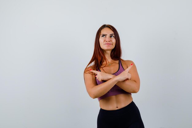 Giovane donna con i capelli lunghi che indossa abbigliamento sportivo