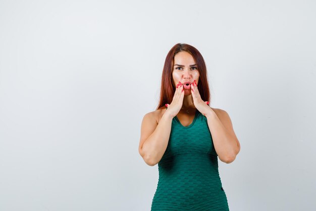 Giovane donna con i capelli lunghi che indossa un bodycon verde