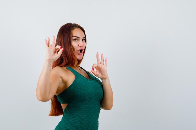 Giovane donna con i capelli lunghi che indossa un bodycon verde