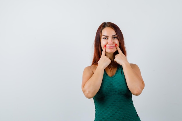 Giovane donna con i capelli lunghi in un bodycon verde