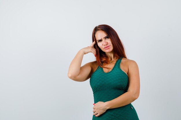 Giovane donna con i capelli lunghi in un bodycon verde