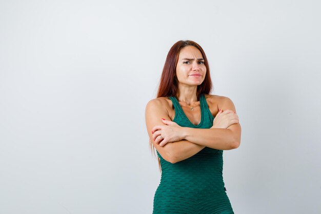 Giovane donna con i capelli lunghi in un bodycon verde