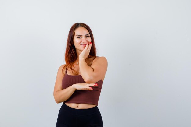 Giovane donna con i capelli lunghi in un top corto marrone