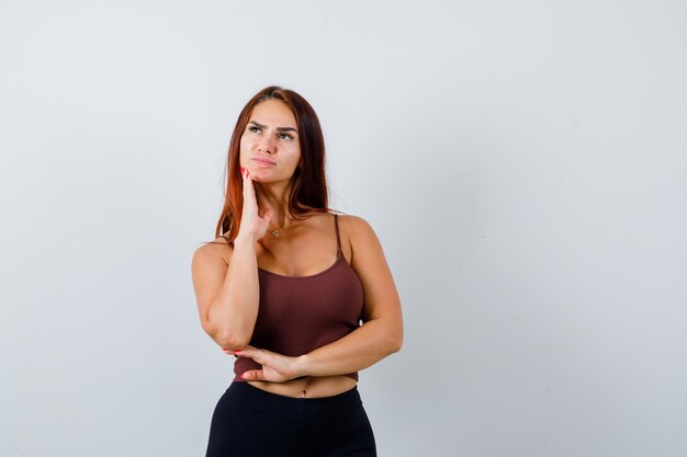 Giovane donna con i capelli lunghi in un top corto marrone