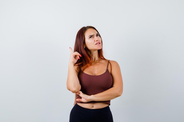 Giovane donna con i capelli lunghi in un top corto marrone