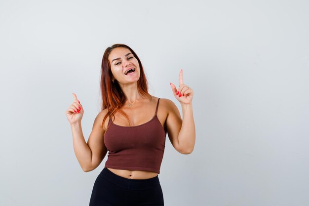 Giovane donna con i capelli lunghi in un top corto marrone