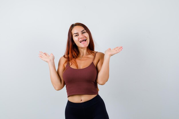 Giovane donna con i capelli lunghi in un top corto marrone