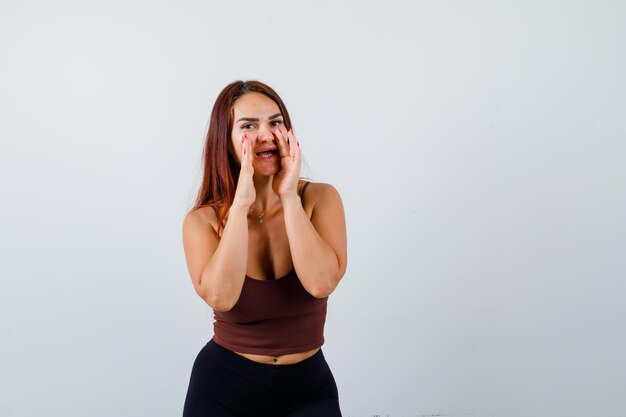 Giovane donna con i capelli lunghi in un top corto marrone