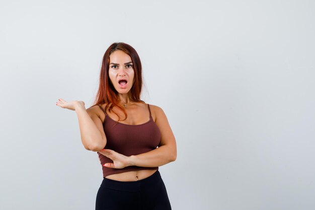 Giovane donna con i capelli lunghi in un top corto marrone