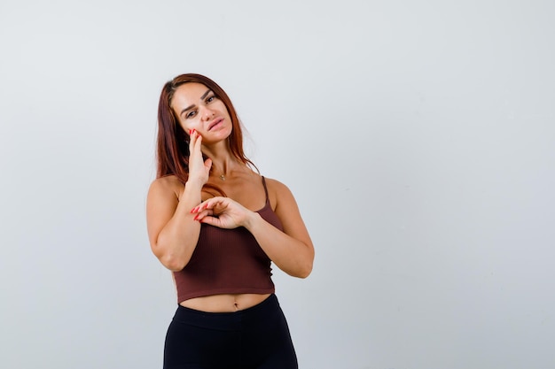 Giovane donna con i capelli lunghi in un top corto marrone