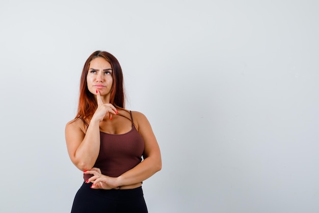 Giovane donna con i capelli lunghi in un top corto marrone