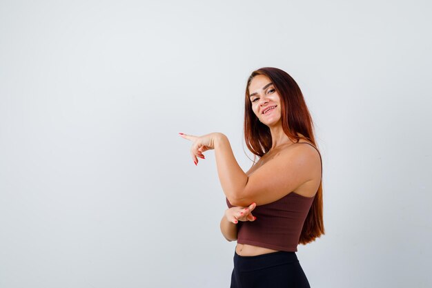 Giovane donna con i capelli lunghi in un top corto marrone