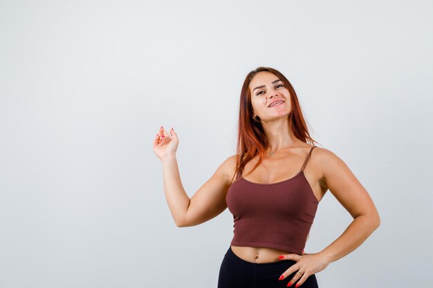 Giovane donna con i capelli lunghi in un top corto marrone