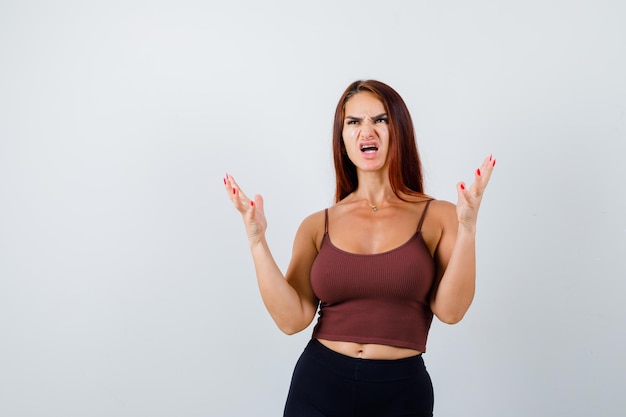 Giovane donna con i capelli lunghi in un top corto marrone