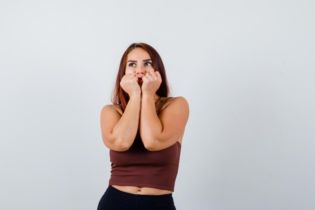 Giovane donna con i capelli lunghi in un top corto marrone