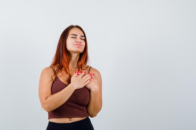 Giovane donna con i capelli lunghi in un top corto marrone