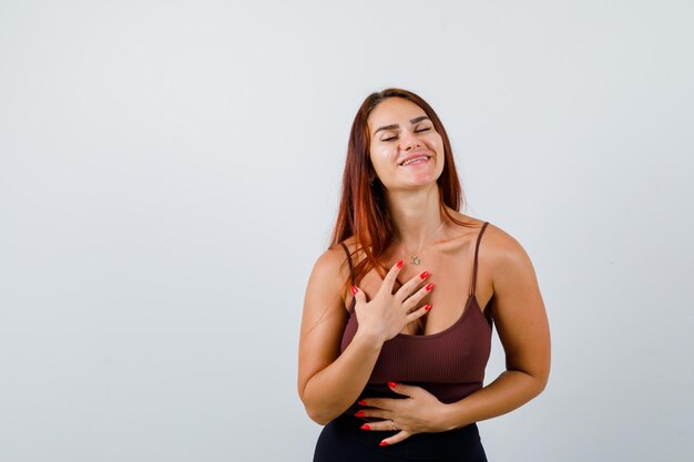 Giovane donna con i capelli lunghi in un top corto marrone