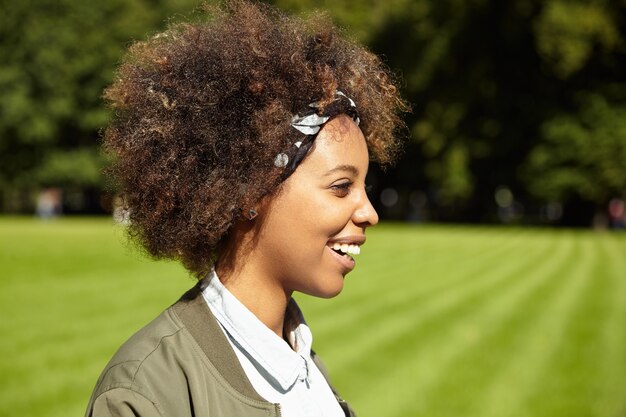 Giovane donna con i capelli ricci che indossa bandana