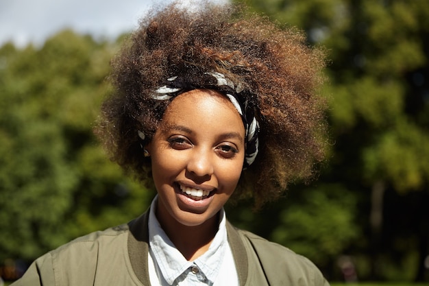 Giovane donna con i capelli ricci che indossa bandana