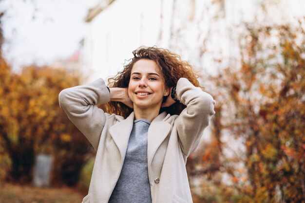 Giovane donna con i capelli ricci nel parco