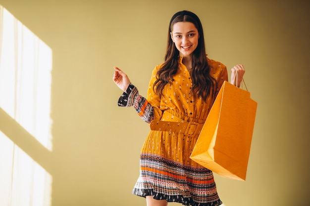 Giovane donna con i sacchetti di shopping in un bel vestito