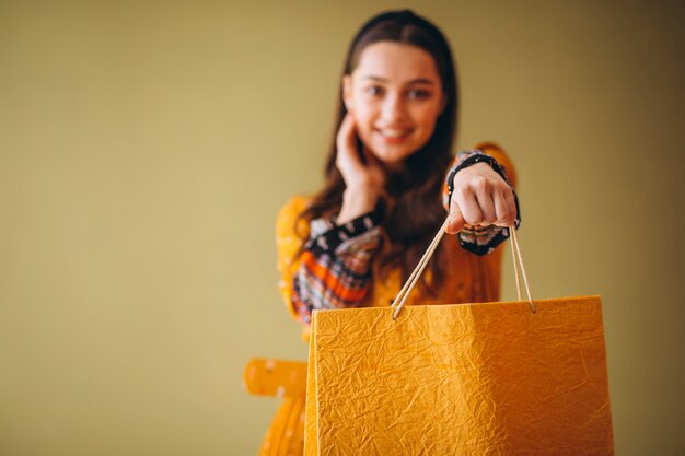 Giovane donna con i sacchetti di shopping in un bel vestito