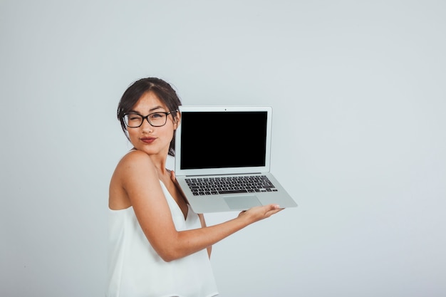 Giovane donna con il computer portatile ammiccante