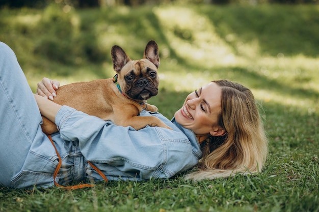 Giovane donna con il suo animale domestico bulldog francese in park