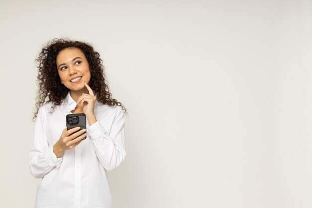 Giovane donna con il telefono su sfondo bianco