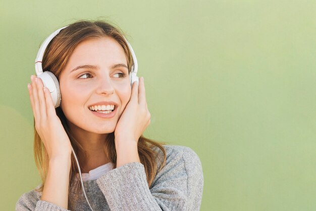 Giovane donna con la cuffia sulla sua musica d&#39;ascolto capa