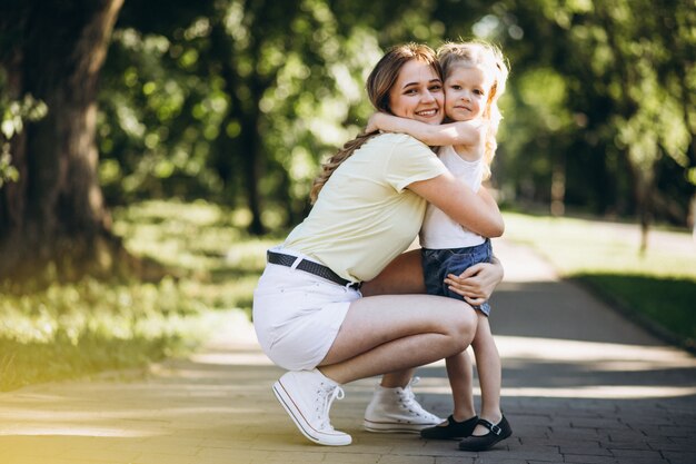 Giovane donna con la piccola figlia che cammina nel parco