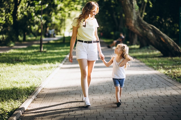 Giovane donna con la piccola figlia che cammina nel parco