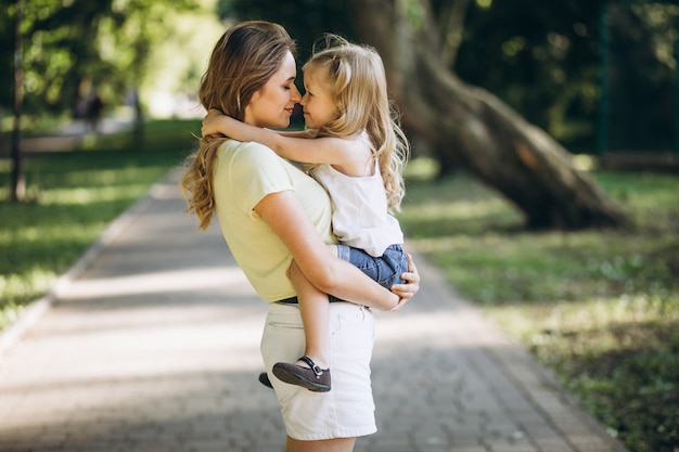 Giovane donna con la piccola figlia che cammina nel parco