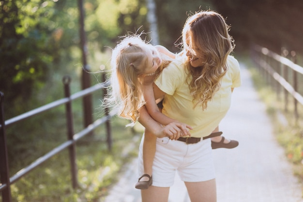 Giovane donna con la piccola figlia che cammina nel parco