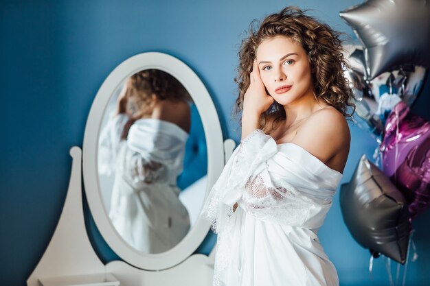 Giovane donna con lunghi capelli ricci in posa