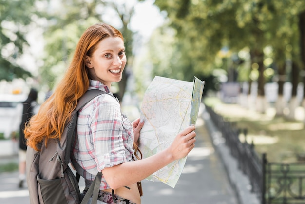 Giovane donna con mappa nel parco